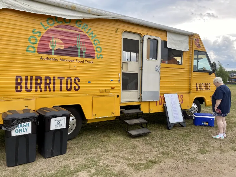 A yellow campervan-style food truck advertising Mexican food.