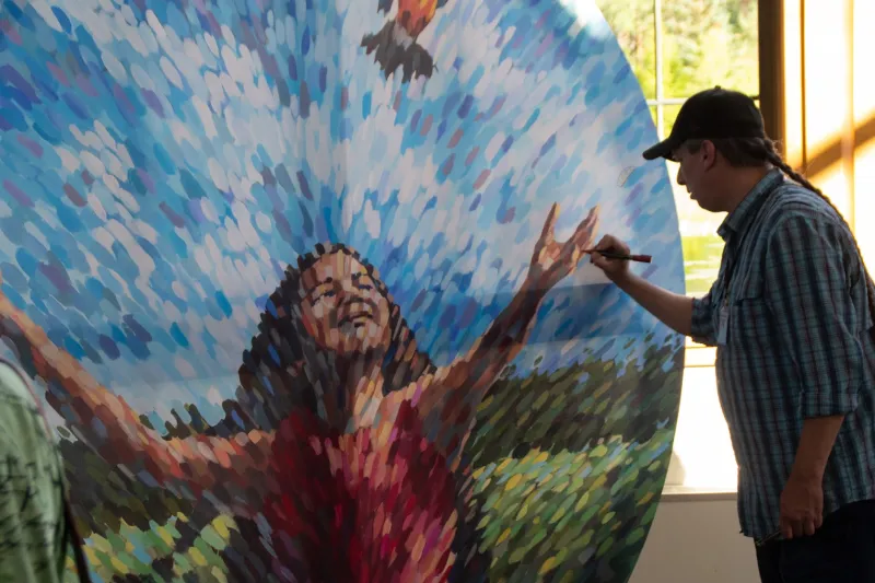 Haudenosaunee artist David Kanietakeron Fadden, painting "The Release", which depicts a young girl releasing a bird.