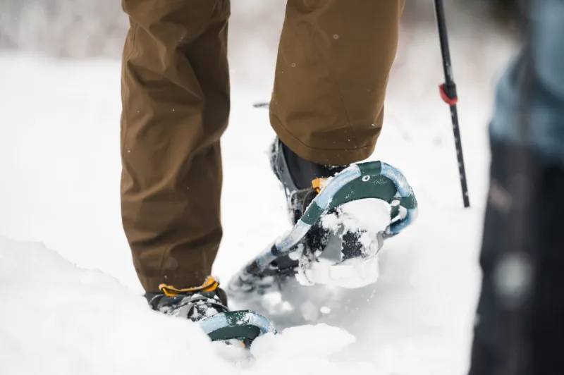 A person walks through the snow in snowshoes
