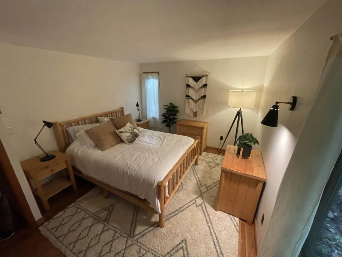 A Tupper Lake vacation rental's hygge bedroom featuring wood furniture