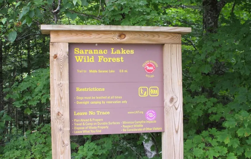 A wooden sign for the Saranac Lakes Wild Forest