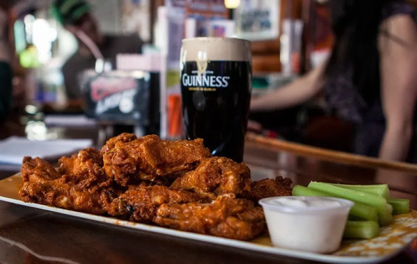 Crispy chicken wings and guiness in a glass