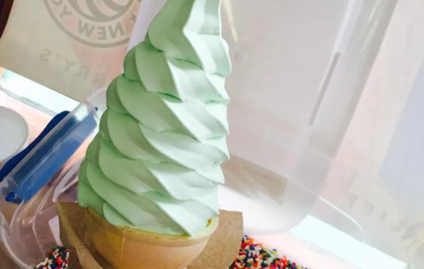 A painted sign of an ice cream cone.