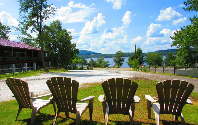 Adirondack chairs in the grass overlooking the lake.