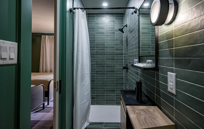 Emerald green tiles with white grout in the walk in shower.