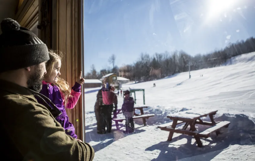 A father holds his daughter at the Pisgah base lodge