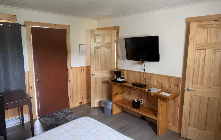 The entry way to a room with knotty pine wainscoting on the walls at Tupper Lake Motel.