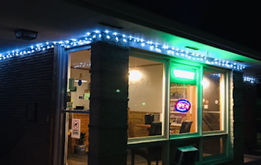 The warm glow from inside radiates out into the night at Tupper Lake Motel.