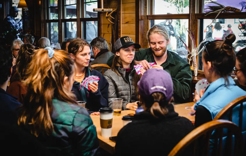 A group sits at a booth and plays card games in the Beer Hall.