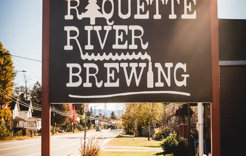 The sign by the road displaying the Raquette River Brewing logo