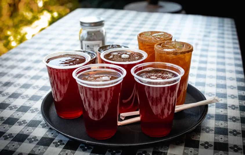 A platter full of perfectly poured red ales on a table.