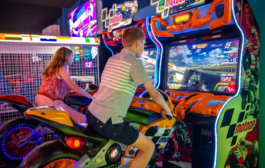 Kids ride virtual motorcycles.