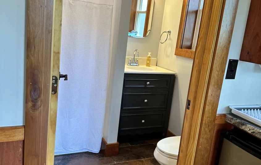 Couch with side tables and sconces surrounding adirondack art