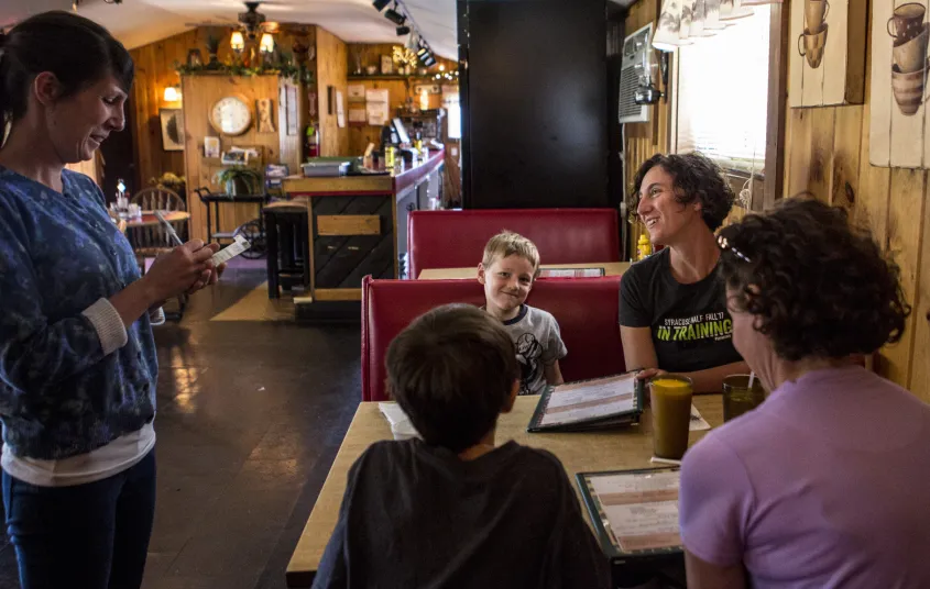 A family sits in a booth with menus.