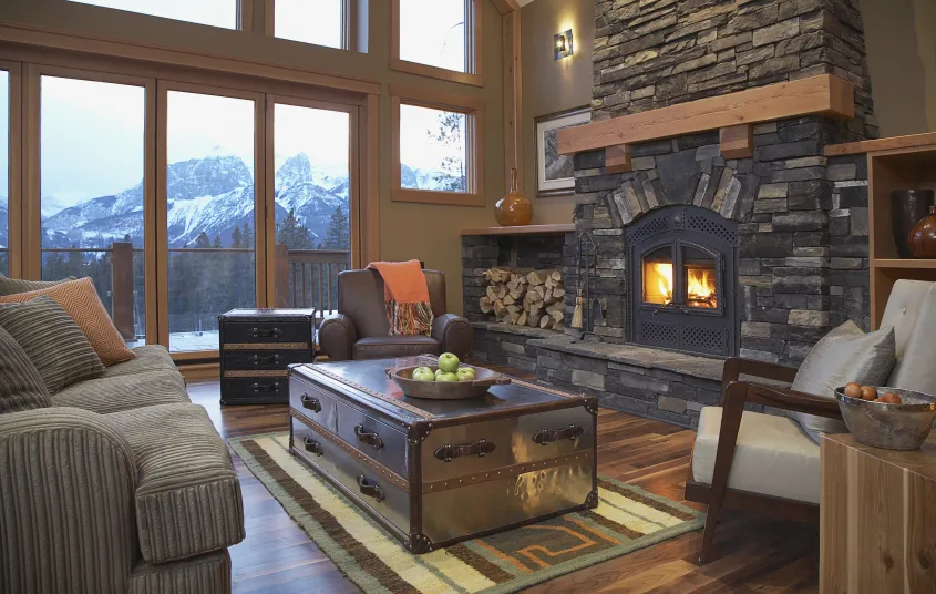 A grand living room with stone hearth and mountain views