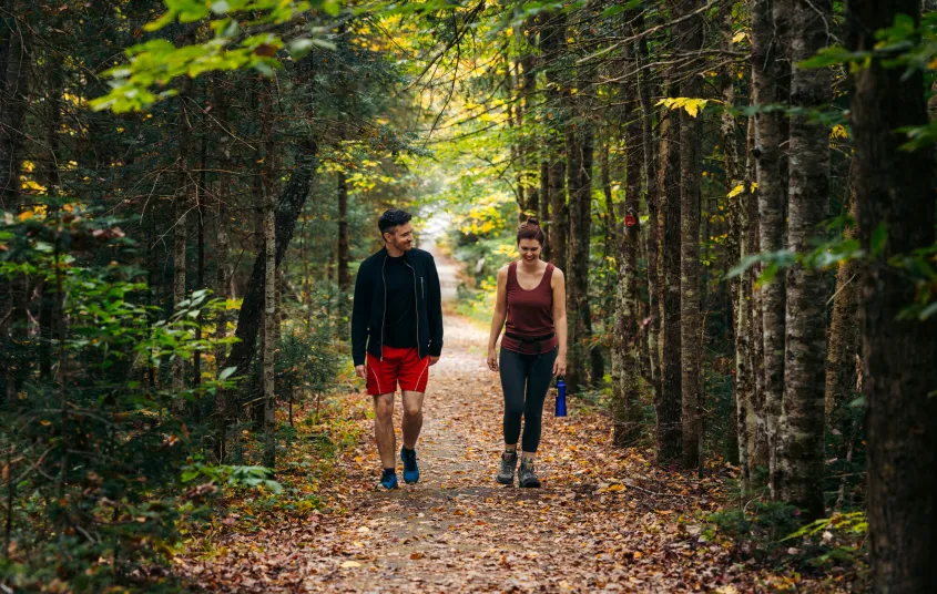 A couple walking along a flat trail during fall