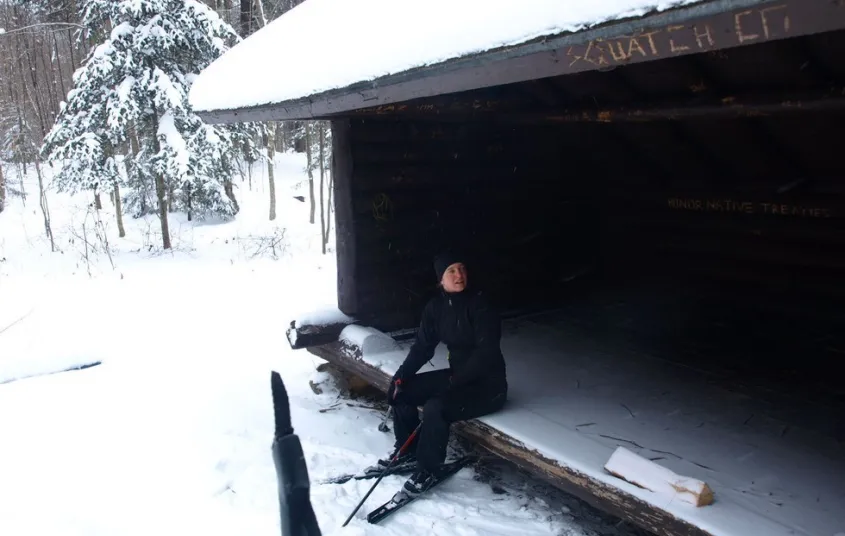 Someone sitting in a lean-to in the winter