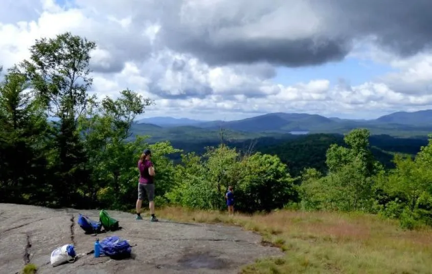 A hiker a top a partially open mountain