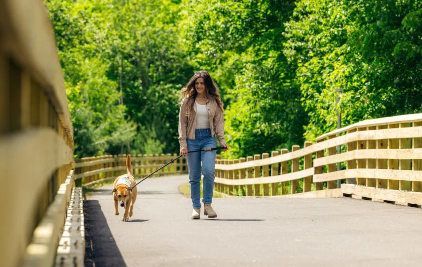 A woman walking her dog on the Rail Trail
