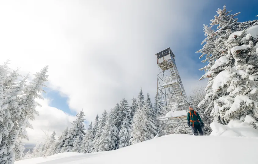 A snowshoer near the firetower on Owls Head Mountain in the winter