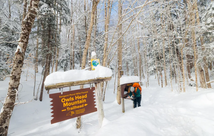 A snowshoer signs into a trailhead register