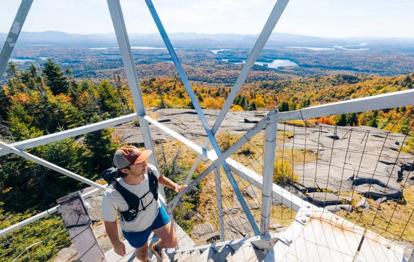 A hiker going up a fire tower in the fall
