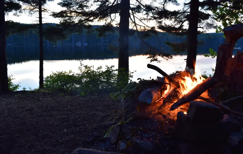 A campfire at the edge of the water