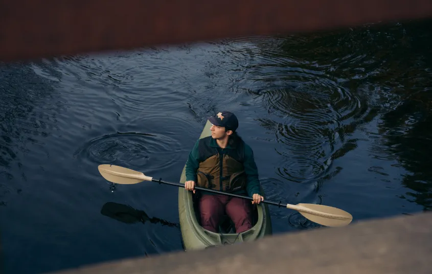 A paddler goes under a bridge