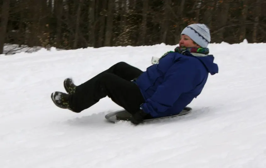 Families gather and play on the groomed sledding hill.