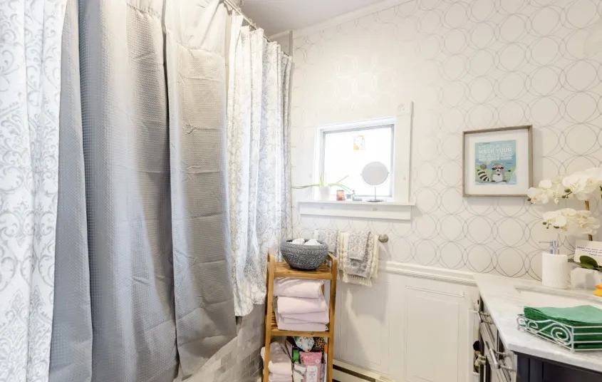 A bright white bathroom with light blue accents and orchids