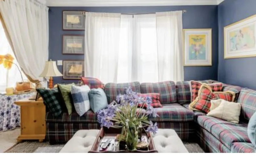 The formal sitting area with large window and plaid sectional couch