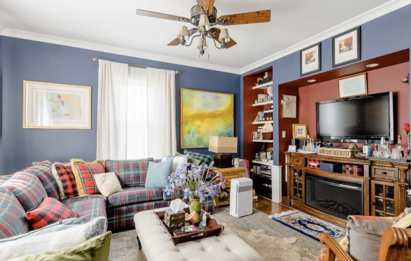 A comfortable blue living room with tv and fireplace.