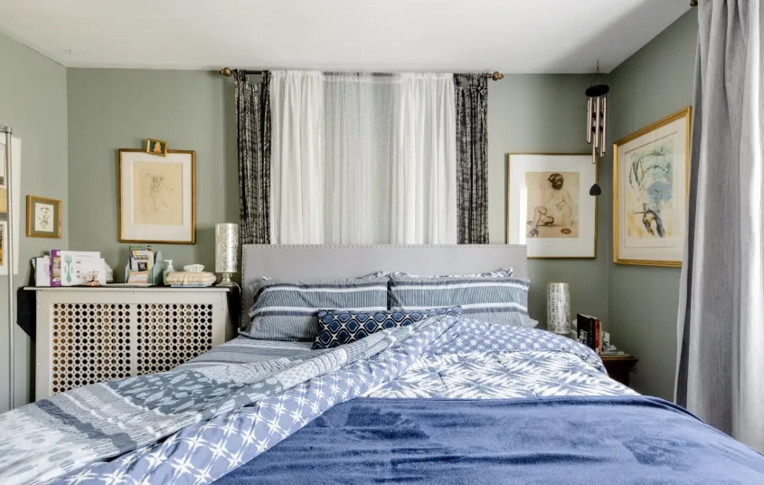 A bright and light three season room with linen curtains and cane furniture.