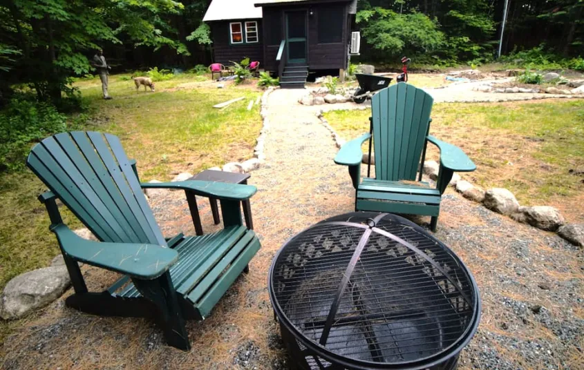 Outdoor fireplace and green adirondack chairs at Rockledge Cabins & Retreats 