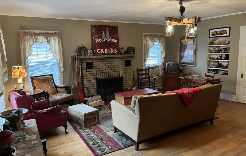 A roaring fire in a brick fire place and Northwoods Cabin sign on the mantle.