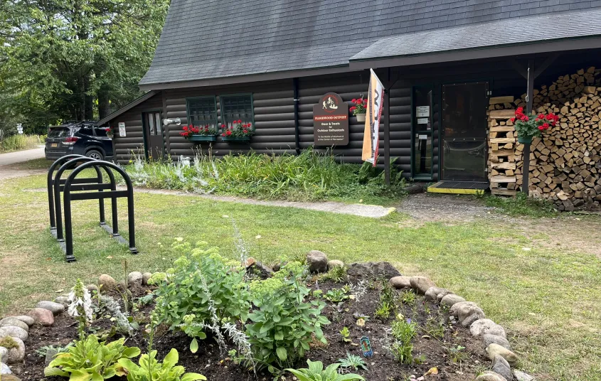 Exterior of the Floodwood Outpost with small garden and bike rack.