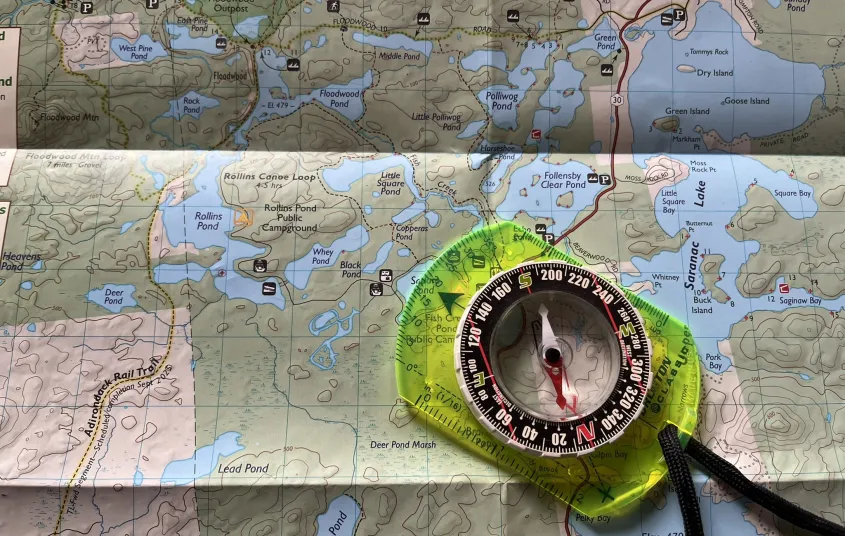 A map with a compass laying on top.