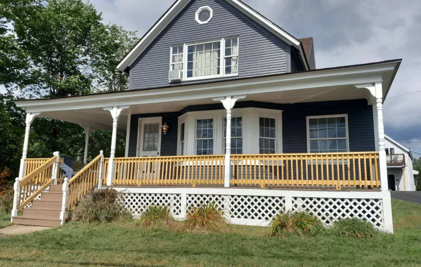 A blue house with white trim at the Sara Placid Inn & Suites.