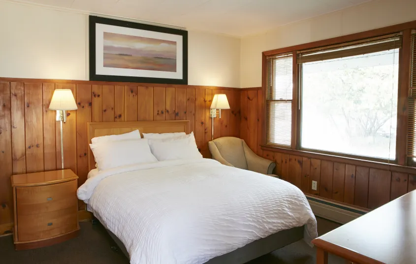 Plush white linens on a king bed at The Ashley.