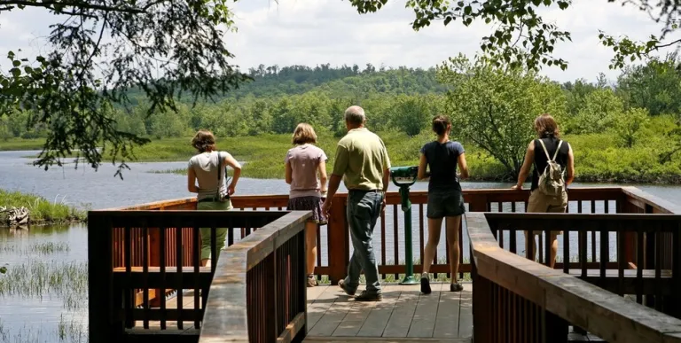 A family gazes out at the water from a large waterside structure