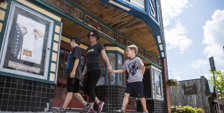 Family walks past the Adriondack State Theater in Tupper Lake