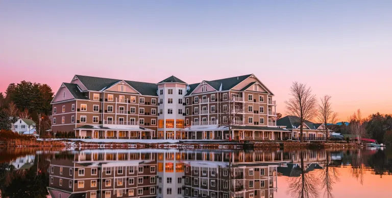 The exterior reflects off Lake Flower in a pink sunset