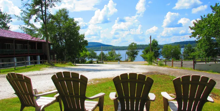 Adirondack chairs in the grass overlooking the lake.