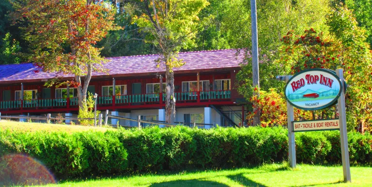 The green grass and shrubs and the red roofing of the Red Top Inn.