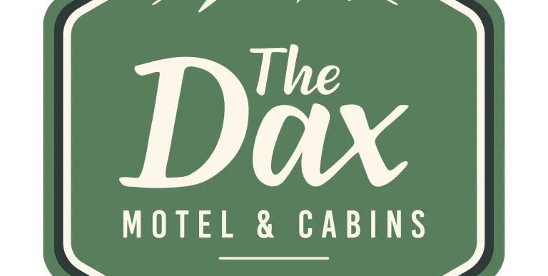 A green hexagon badge with white lettering for The Dax Motel & Cabins EST 1942.