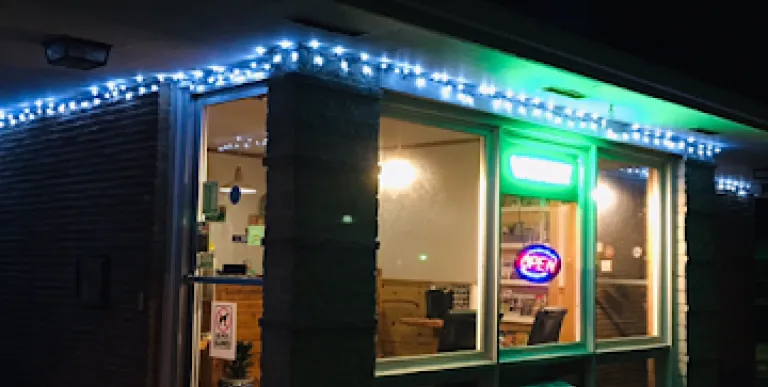 The warm glow from inside radiates out into the night at Tupper Lake Motel.