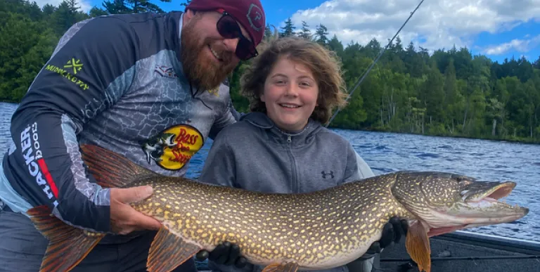 A man and a child hold a pike.