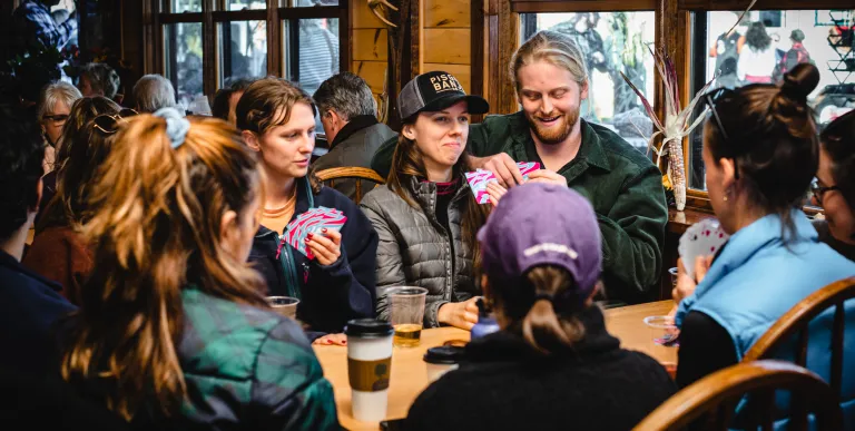 A group sits at a booth and plays card games in the Beer Hall.