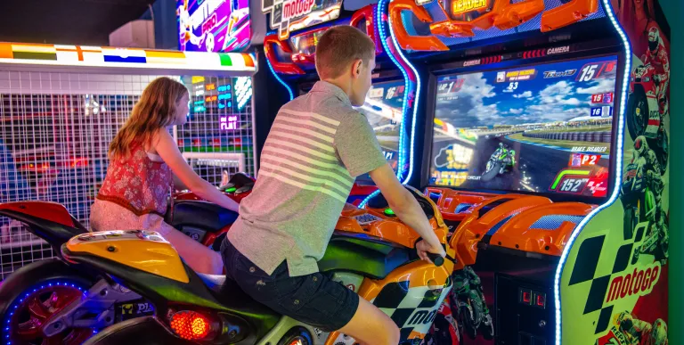 Kids ride virtual motorcycles.