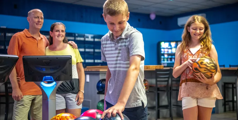 A boy selects the perfect bowling ball.